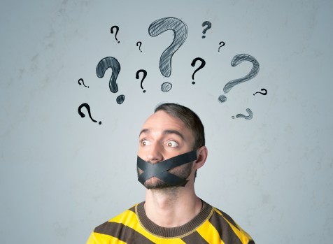 Young man with glued mouth and question mark symbols