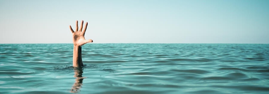 Hand in sea water asking for help. Failure and rescue concept.