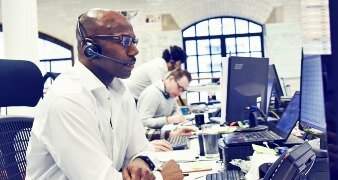 man at an office deak with headset on