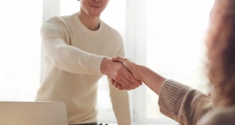 man and woman shaking hands in business meeting